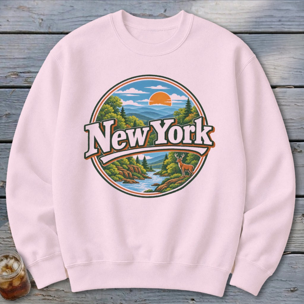 Pink sweatshirt with a circular graphic featuring "New York" over a scenic landscape with a deer.