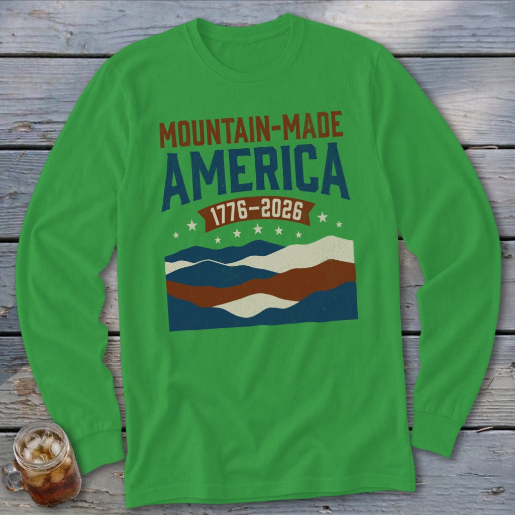 Green long-sleeve shirt with Mountain-Made America 1776-2026 text and wavy mountain graphics.