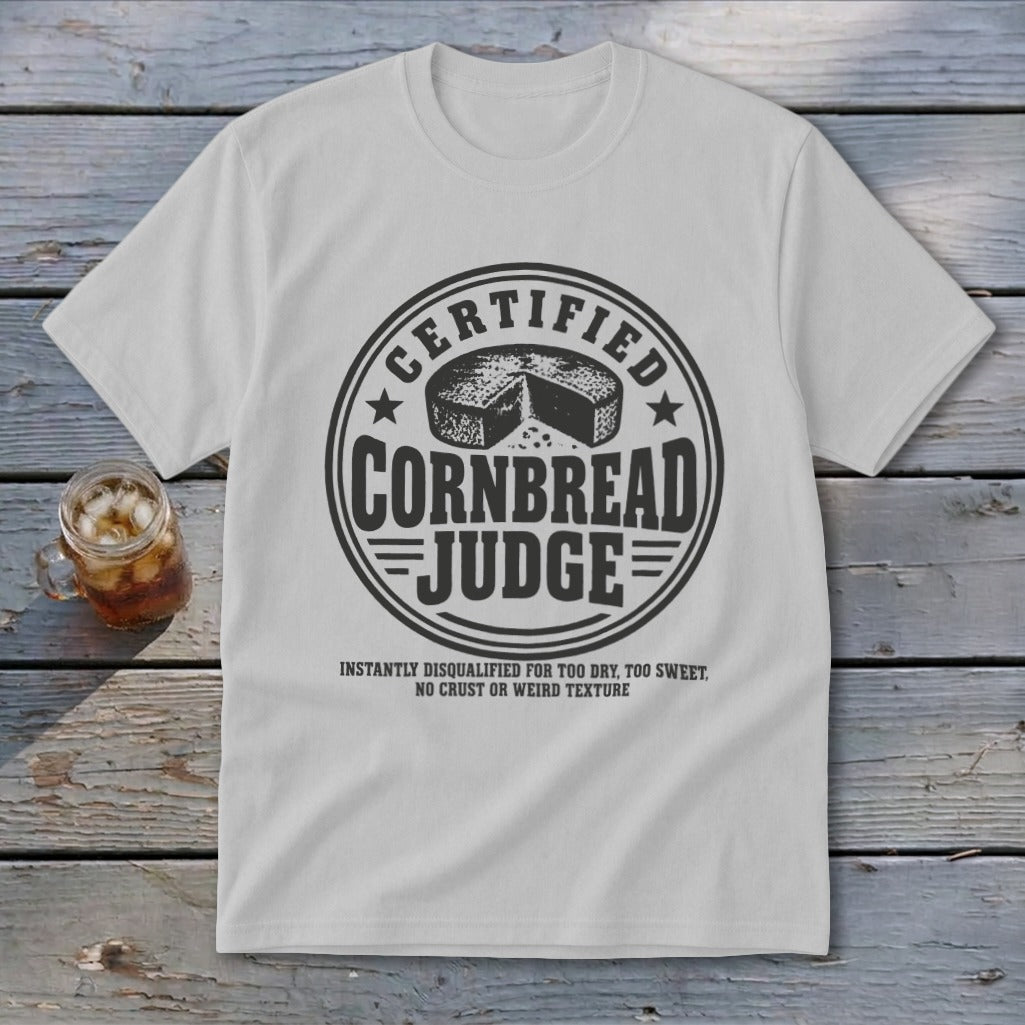 Light gray t-shirt with a vintage-style circular graphic reading Certified Cornbread Judge and humorous disqualification criteria below.