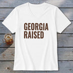 White v-neck t-shirt with brown text "GEORGIA RAISED."
