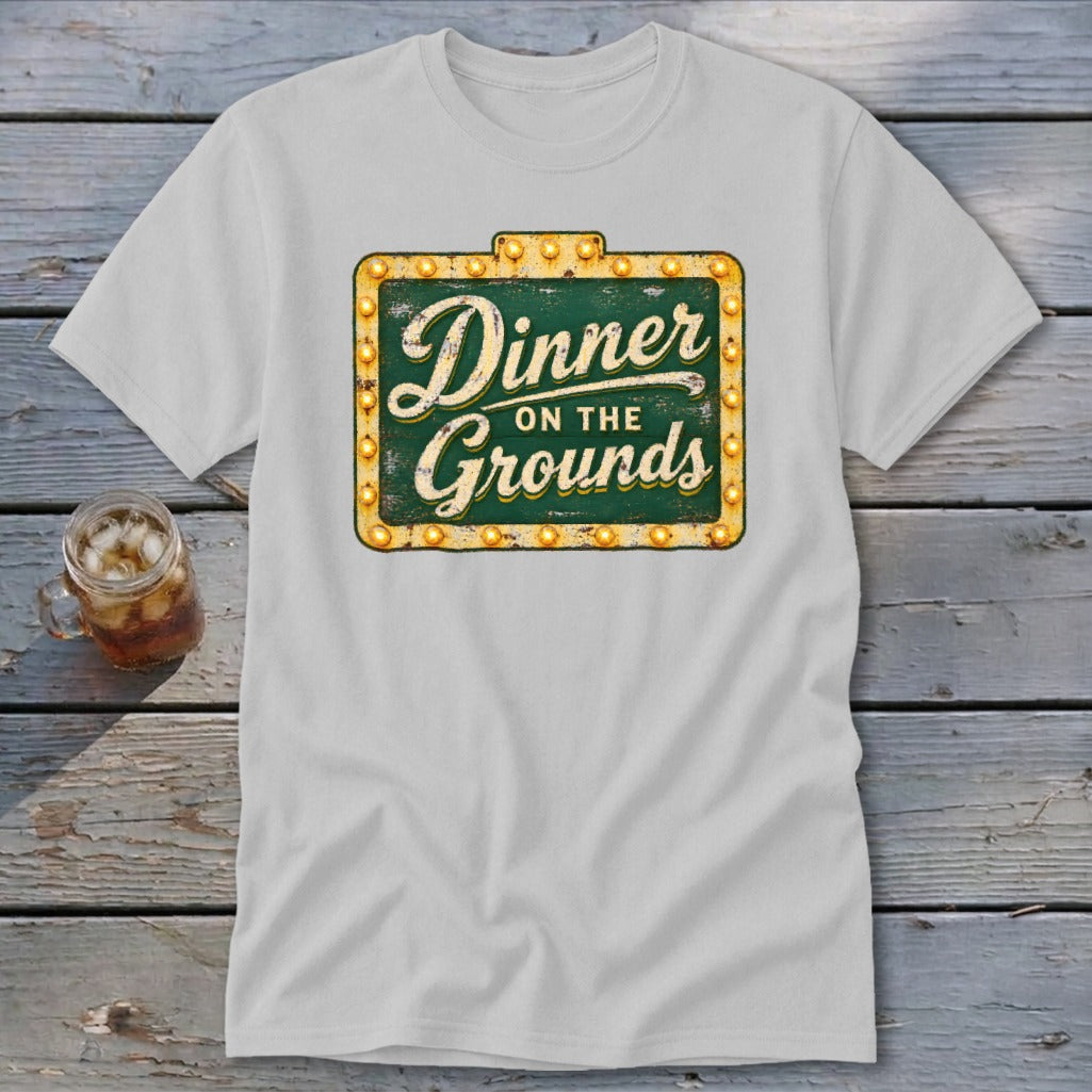 A light gray t-shirt with a vintage green and yellow sign graphic that reads Dinner on the Grounds.