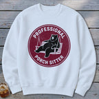 White crewneck sweatshirt with a maroon circular graphic of a bear lounging on a porch swing, reading Professional Porch Sitter.