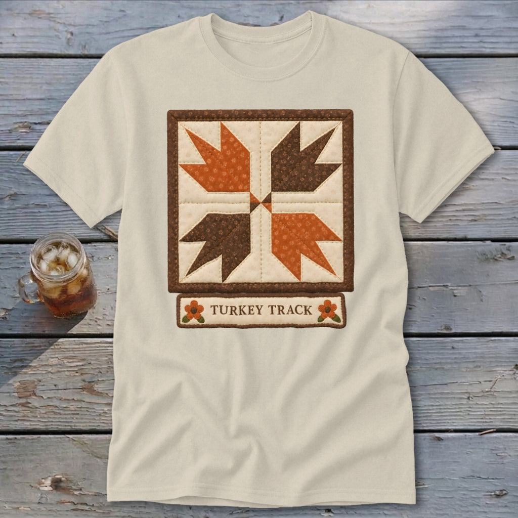 Cream t-shirt with a quilted "Turkey Track" design in brown and orange.