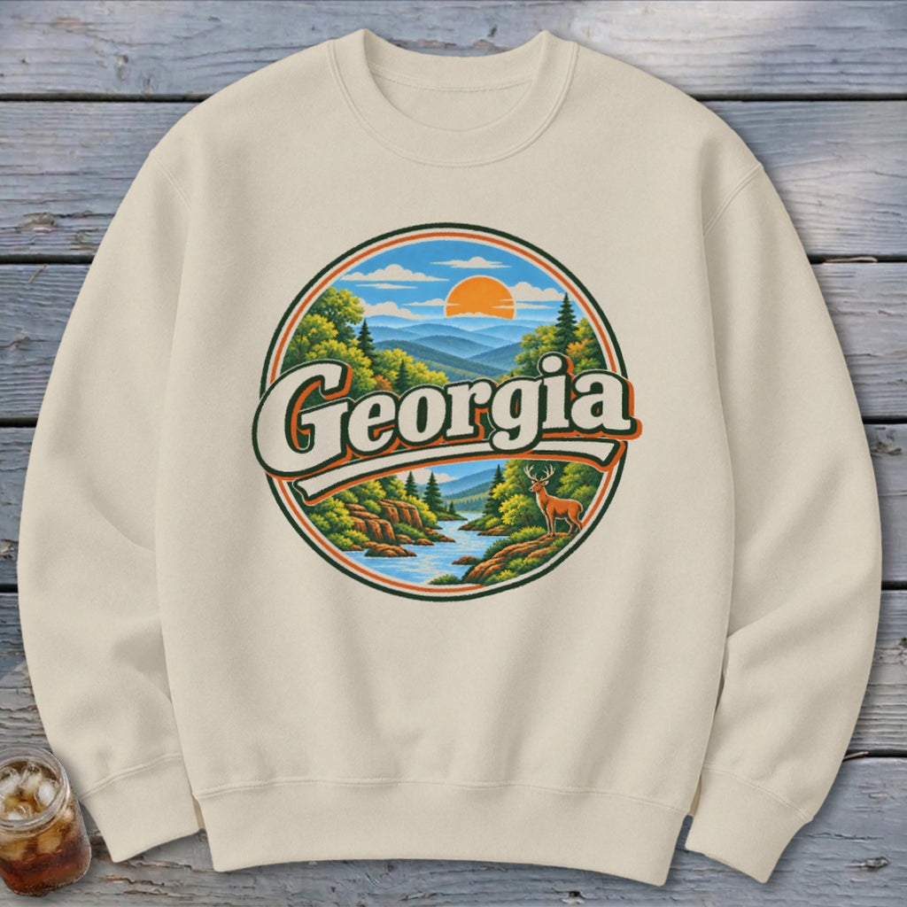 Cream sweatshirt with circular graphic of Georgia mountains, river, deer, and sunset.