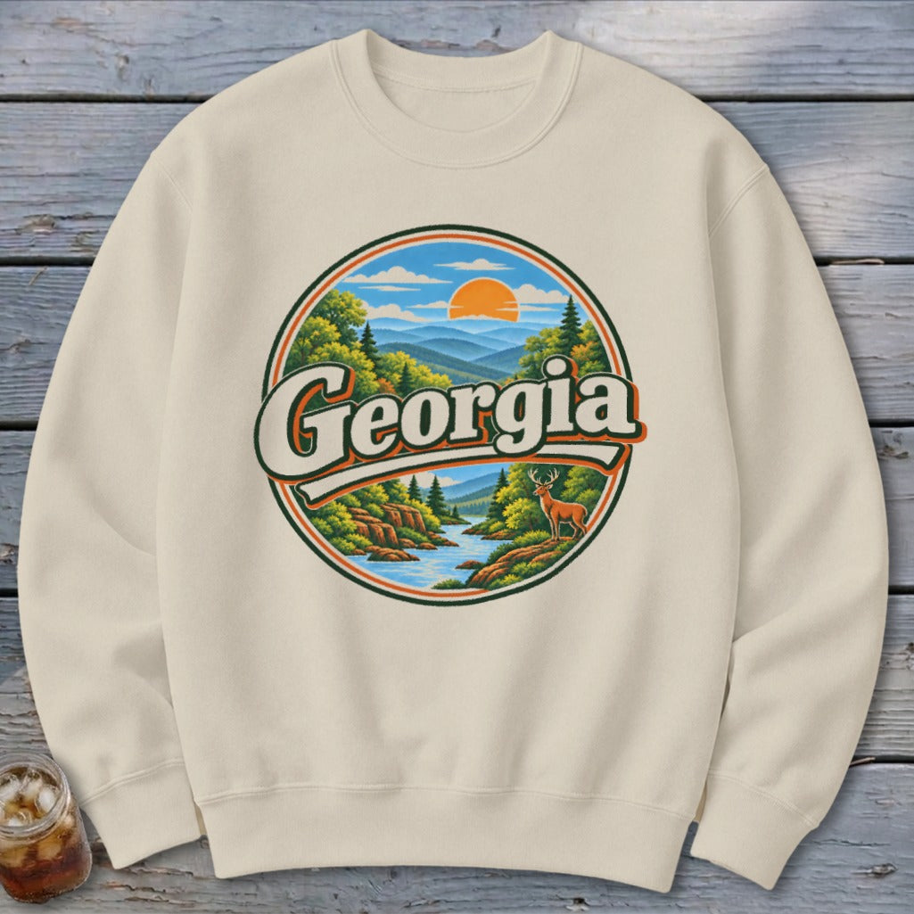 Cream sweatshirt with circular graphic of Georgia mountains, river, deer, and sunset.