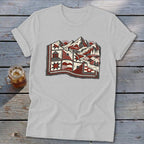 Light gray t-shirt featuring a stylized graphic of a red and white quilt blending into a mountain landscape.