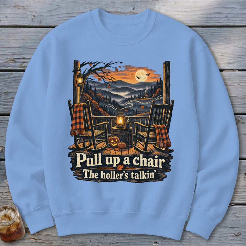 Front of light blue sweatshirt with autumn porch scene and text: "Pull up a chair. The holler's talkin'."
