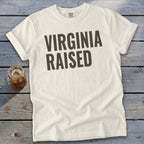 Cream t-shirt with "VIRGINIA RAISED" in dark grey bold text.