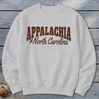 White sweatshirt with "APPALACHIA #North Carolina" graphic in brown.