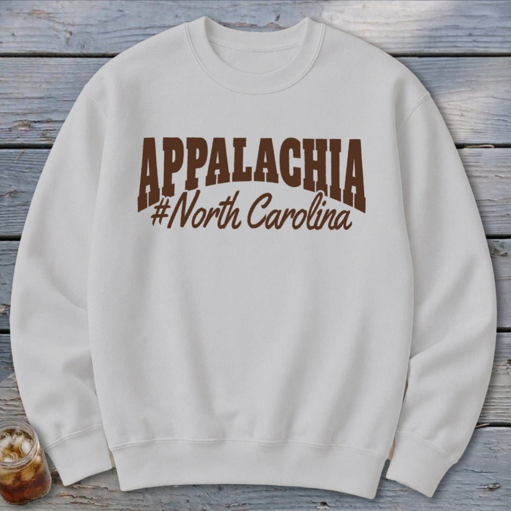 White sweatshirt with "APPALACHIA #North Carolina" graphic in brown.