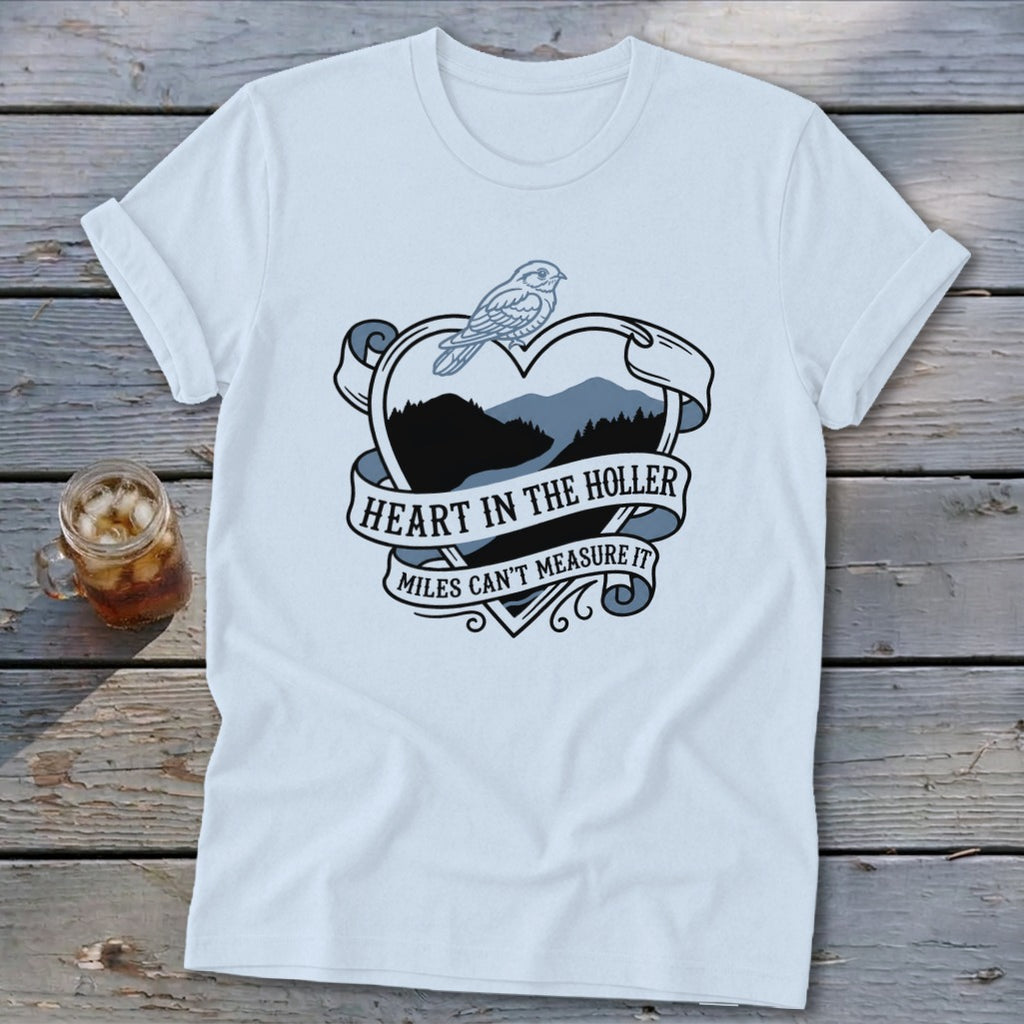 Light blue t-shirt with heart graphic featuring mountains, a bird, and text.