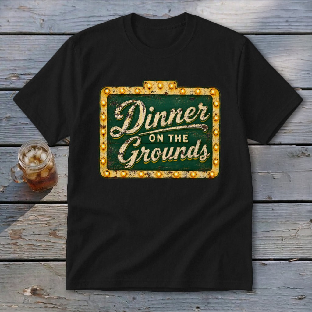 A black t-shirt features a vintage marquee sign graphic that reads Dinner on the Grounds.