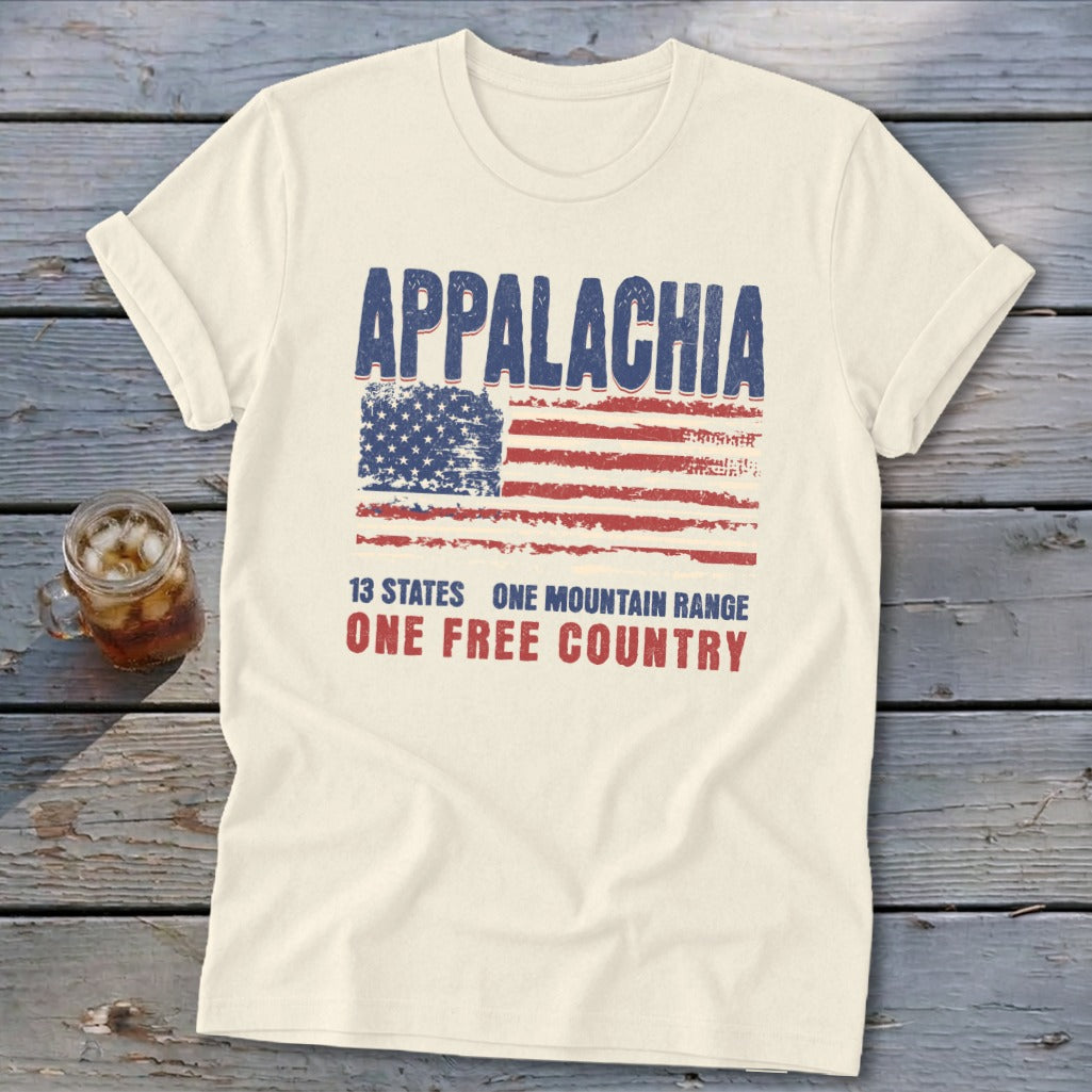 A cream-colored t-shirt printed with a distressed American flag and text that reads Appalachia, 13 states, one mountain range, one free country.
