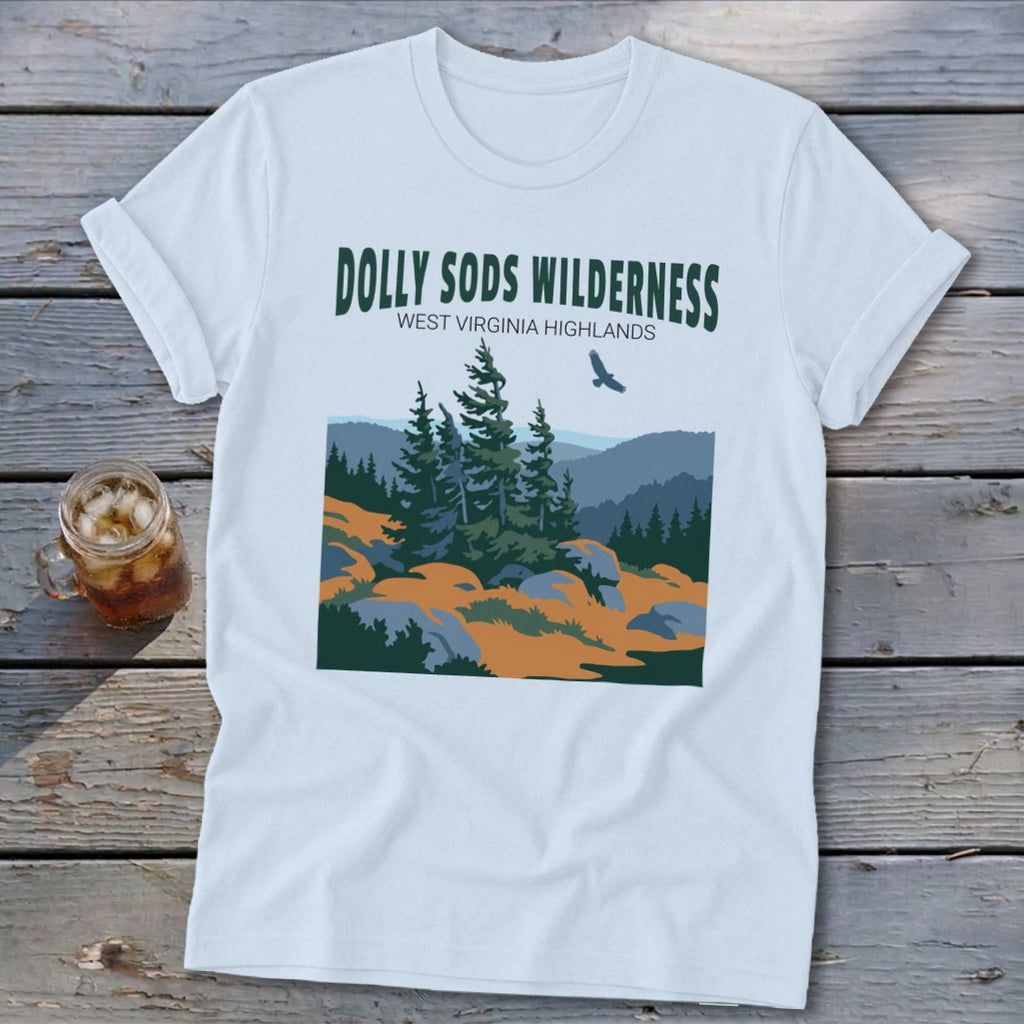A white t-shirt featuring a green graphic and text reading DOLLY SODS WILDERNESS WEST VIRGINIA HIGHLANDS.