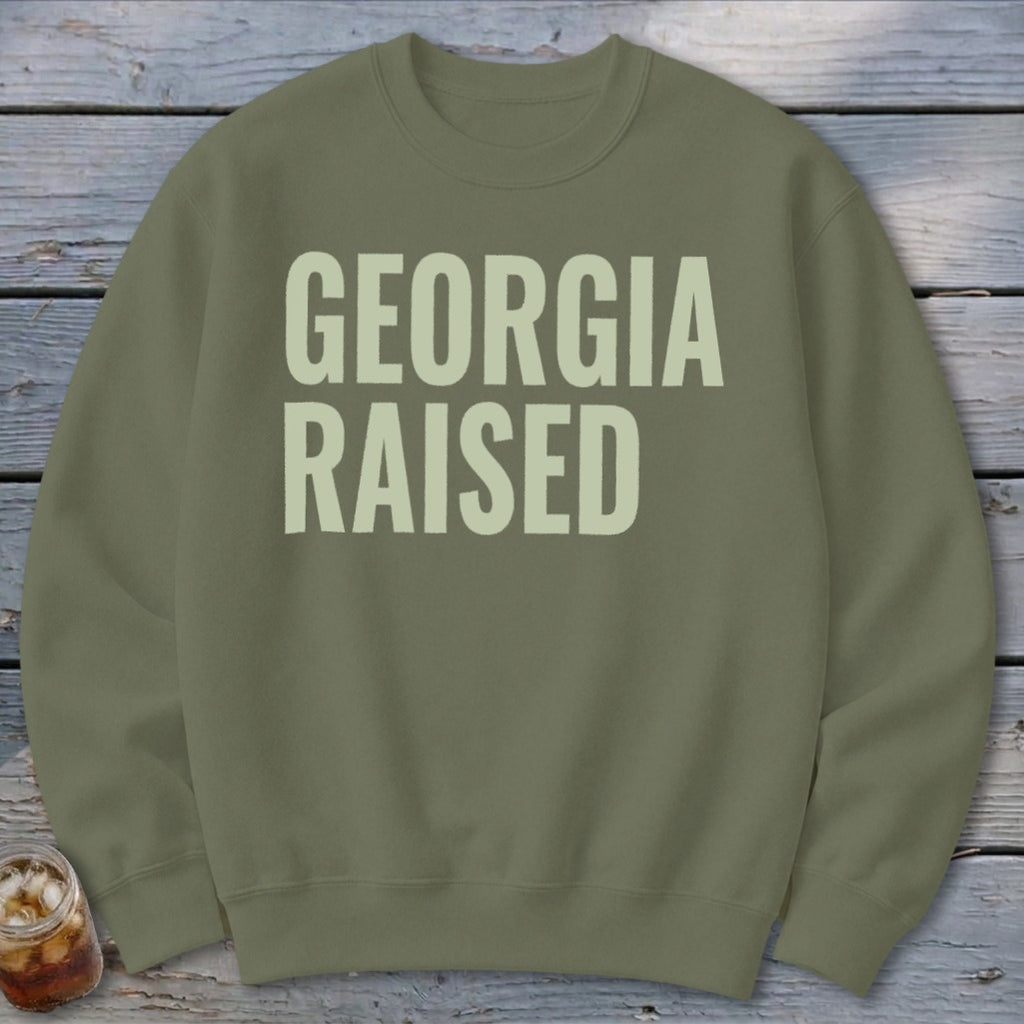 Olive green crewneck sweatshirt with "GEORGIA RAISED" text in light beige.