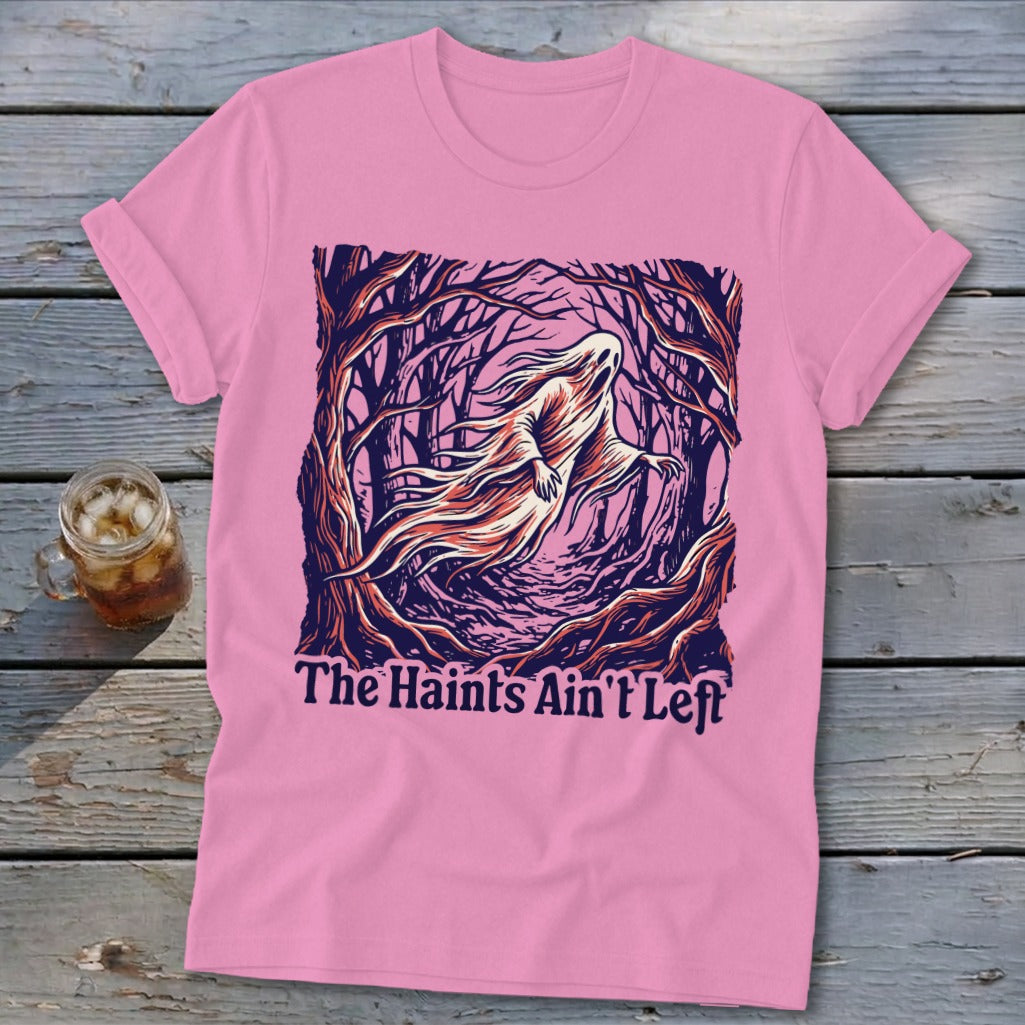 Pink t-shirt with a ghost in a forest and text: The Haints Ain't Left.