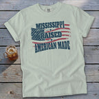 Cream t-shirt with "Mississippi Raised American Made" and distressed American flag graphic.