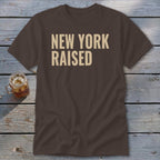 Brown t-shirt with "NEW YORK RAISED" in light tan text.