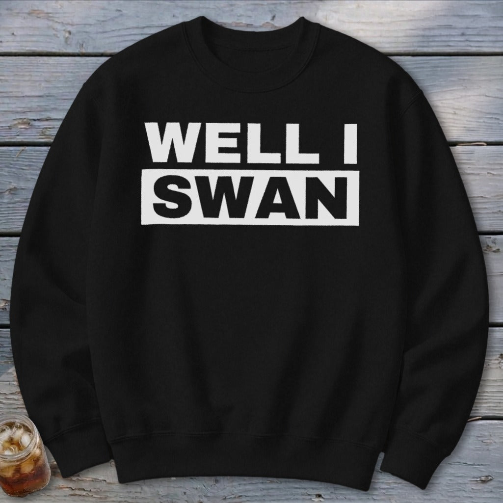 A black crewneck sweatshirt features bold white text that reads WELL I SWAN on the chest.
