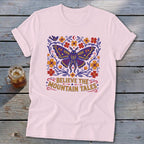 Light pink t-shirt with a colorful moth and floral design, saying "Believe The Mountain Tales".