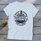 White t-shirt with "Appalachian Born and Bred Still Standing" text and mountain graphic.