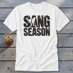 A white t-shirt featuring the distressed black text SANG SEASON with a silhouette of a person digging.