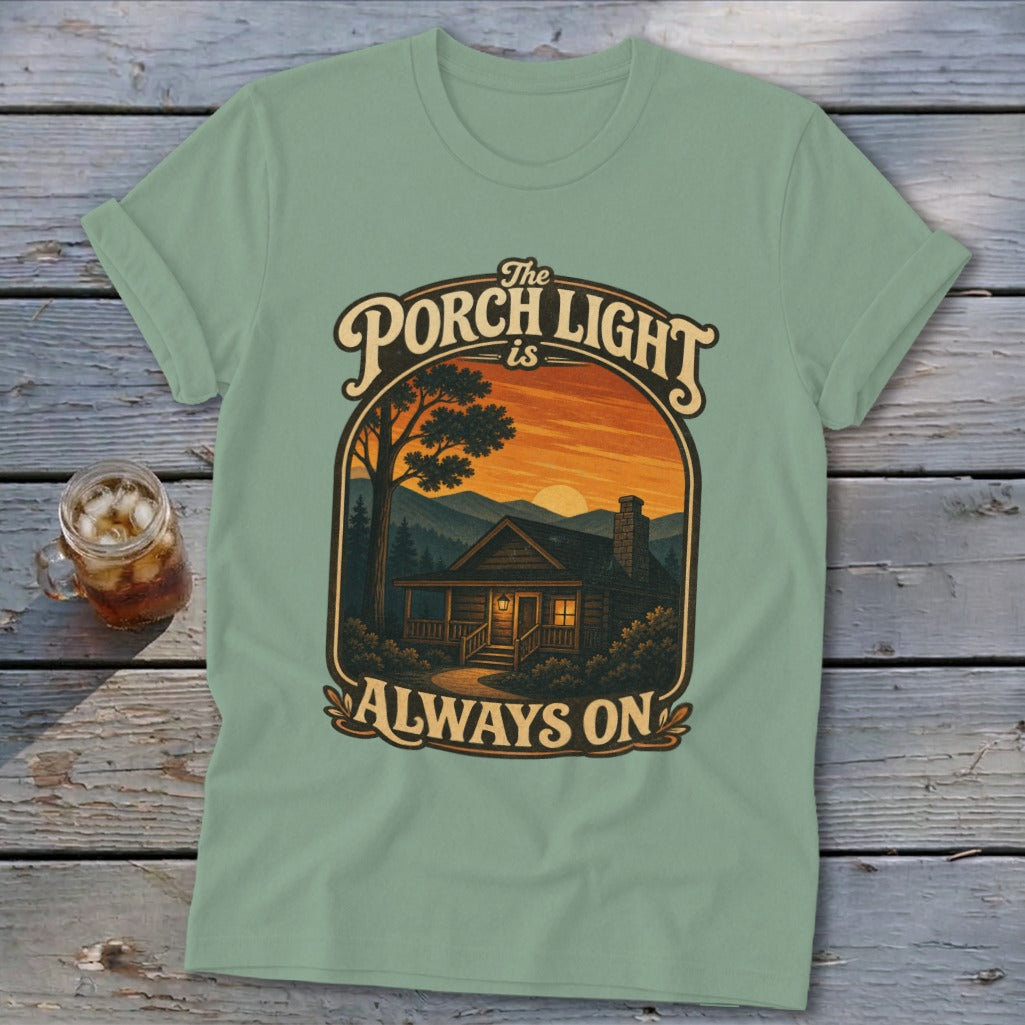 T-shirt graphic: "The Porch Light is Always On" with cabin at sunset.