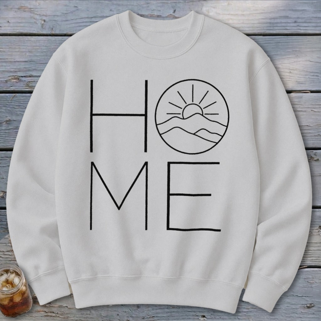 Off-white crewneck sweatshirt featuring a black graphic with the word HOME, where the letter O is replaced by mountains and a sun.
