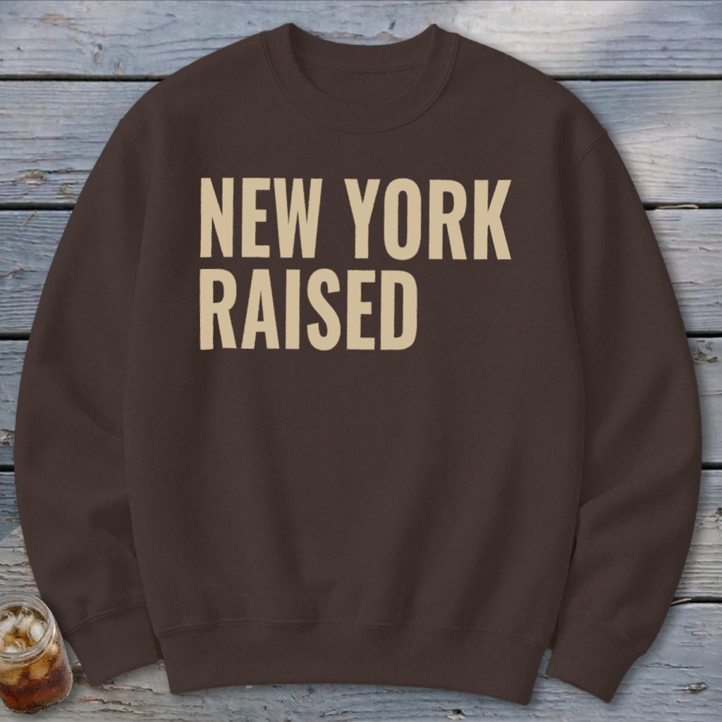 Brown sweatshirt with "NEW YORK RAISED" printed in beige text.