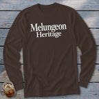 Dark brown long-sleeve t-shirt with white text reading Melungeon Heritage on a rustic wooden background.