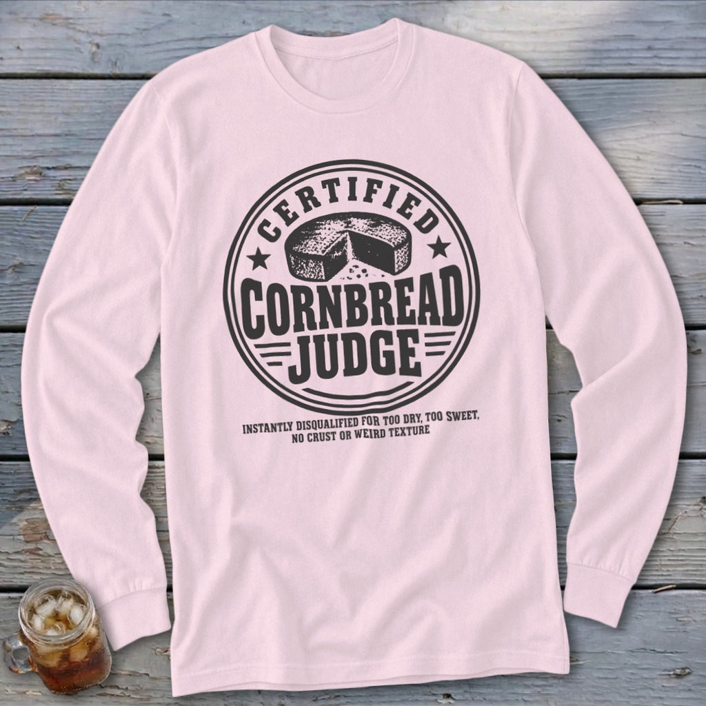 Light pink long-sleeved t-shirt with a round emblem reading Certified Cornbread Judge and humorous disqualification criteria.