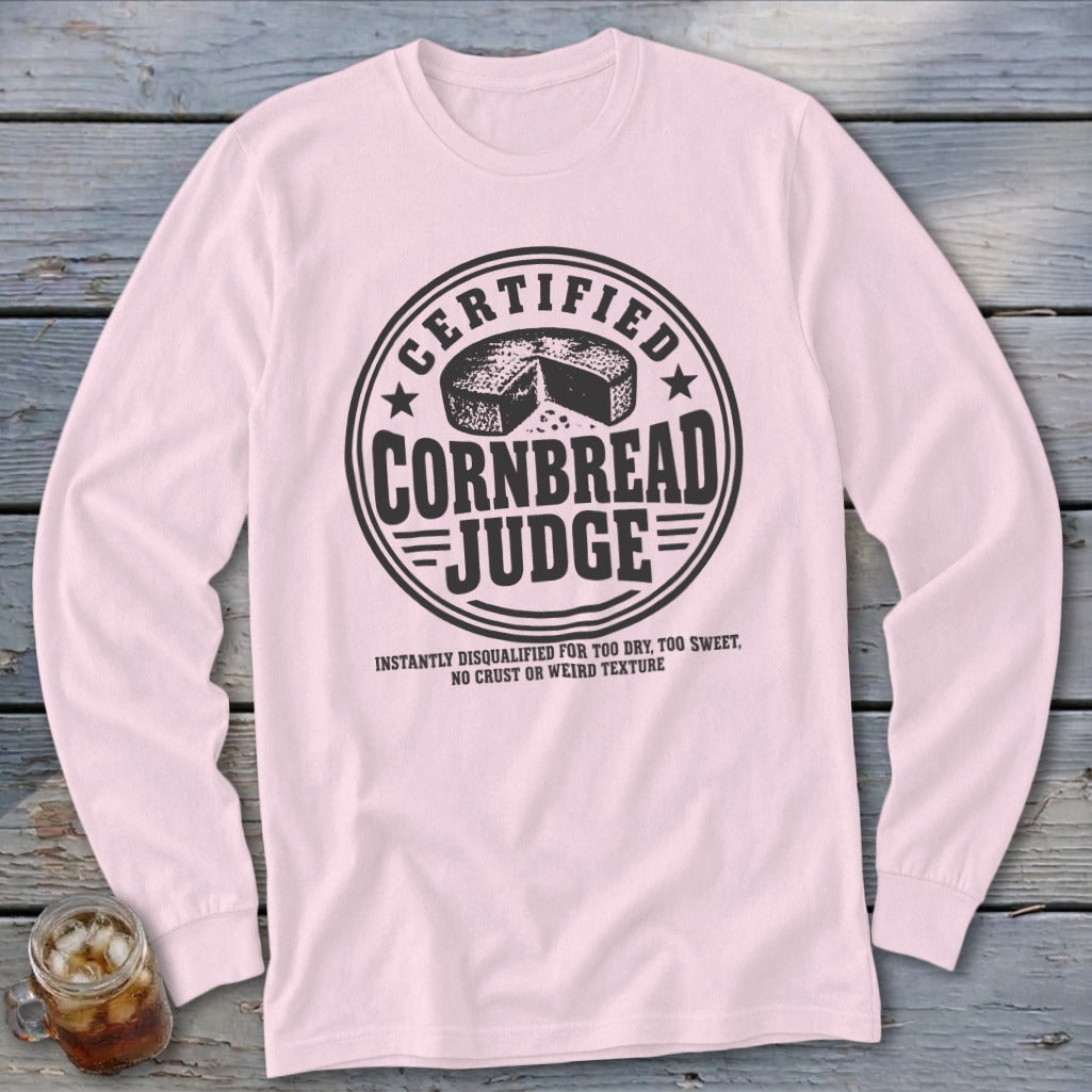 Light pink long-sleeved t-shirt with a round emblem reading Certified Cornbread Judge and humorous disqualification criteria.