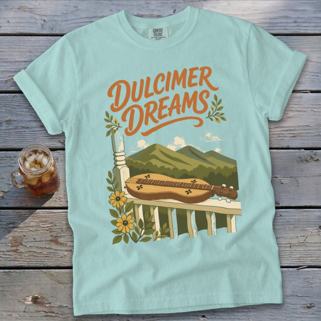 Light blue t-shirt with "Dulcimer Dreams" text and a dulcimer on a porch railing.
