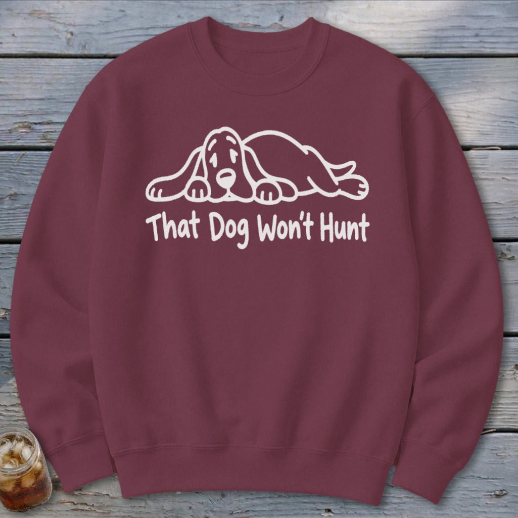 Maroon crewneck sweatshirt featuring a white line drawing of a sad hound dog and the text That Dog Won't Hunt.