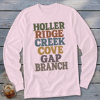 A light pink long-sleeve t-shirt features multi-colored stacked text reading HOLLER RIDGE CREEK COVE GAP BRANCH.