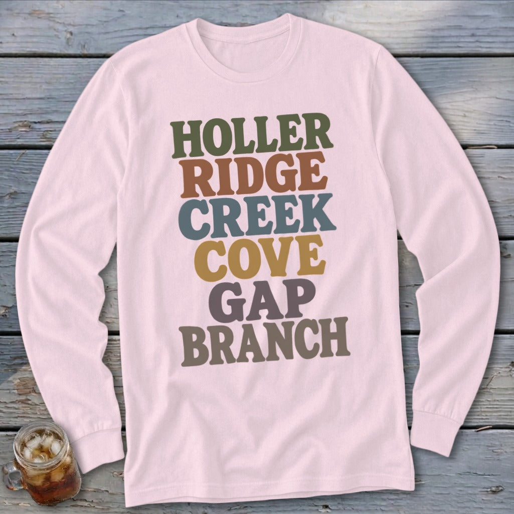 A light pink long-sleeve t-shirt features multi-colored stacked text reading HOLLER RIDGE CREEK COVE GAP BRANCH.