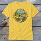 Yellow t-shirt with South Carolina landscape graphic featuring a river and deer.
