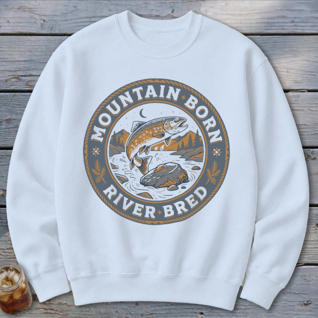 White sweatshirt with a circular graphic of a jumping trout and text "Mountain Born River Bred".