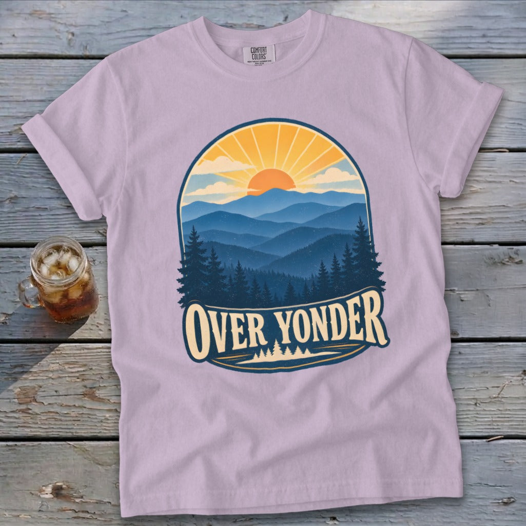 A light purple t-shirt features a graphic of mountain ranges, pine trees, and the text OVER YONDER.