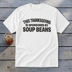 A white short-sleeve t-shirt with black text that reads THIS THANKSGIVING IS SPONSORED BY SOUP BEANS.