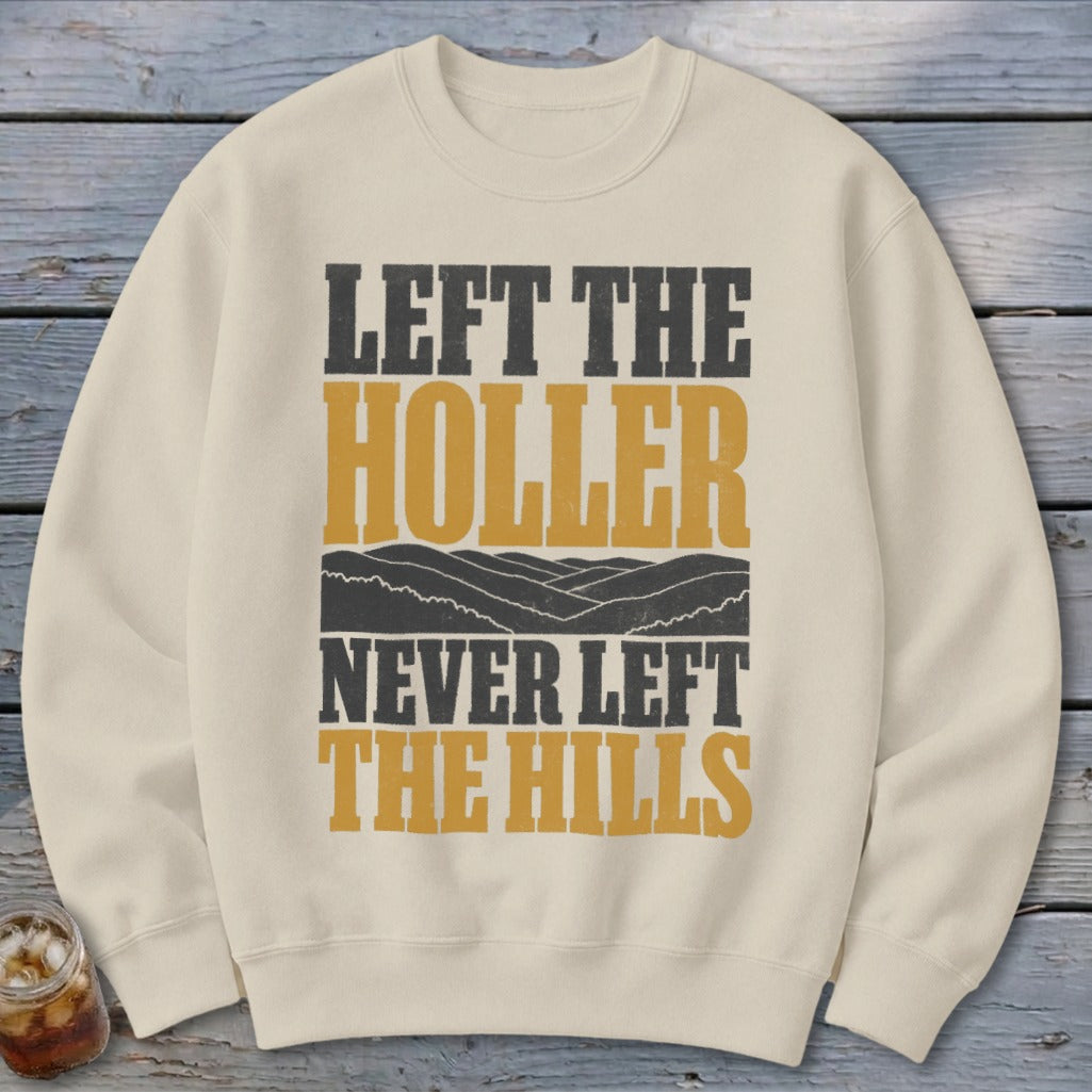 Cream sweatshirt with text "LEFT THE HOLLER NEVER LEFT THE HILLS" and mountain graphic.