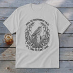 Light gray t-shirt featuring a black circular graphic of a bird, cornstalks, and text.