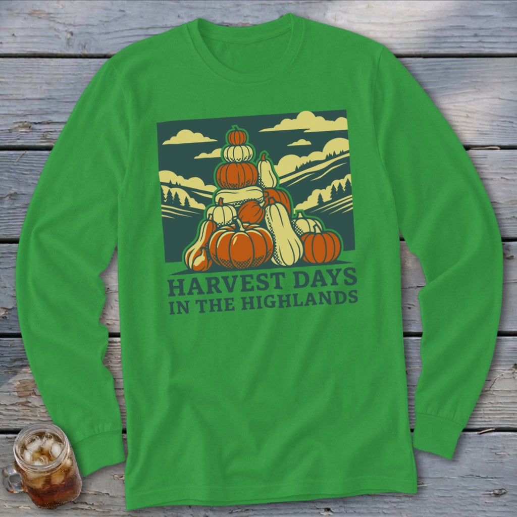 Green long-sleeve t-shirt featuring a graphic of stacked pumpkins, hills, and the text Harvest Days in the Highlands.