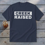 Navy t-shirt with white text reading "CREEK RAISED"