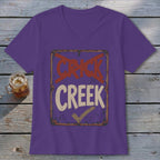 Purple v-neck t-shirt with a distressed sign graphic saying "CRICK" with a red X through it and "CREEK" with a checkmark.