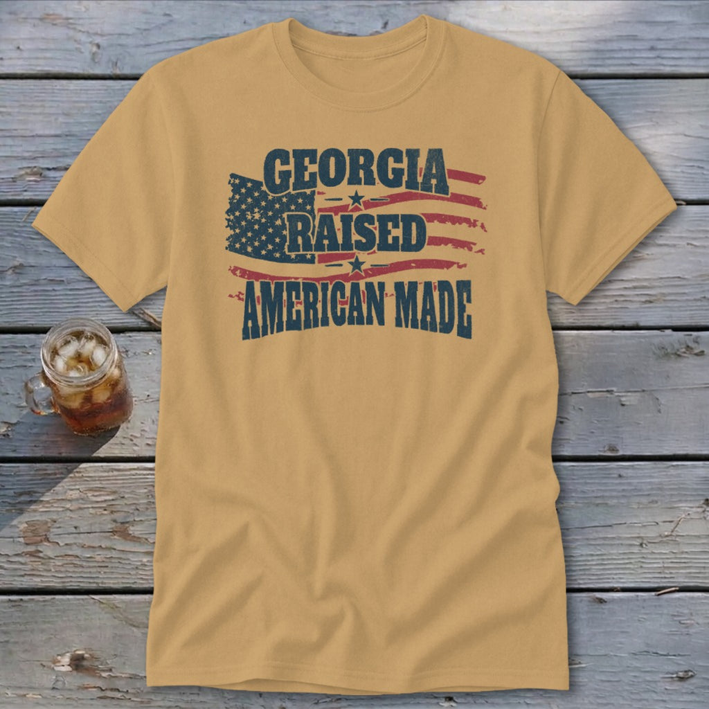 Golden brown t-shirt featuring a distressed American flag and text that reads Georgia Raised American Made.