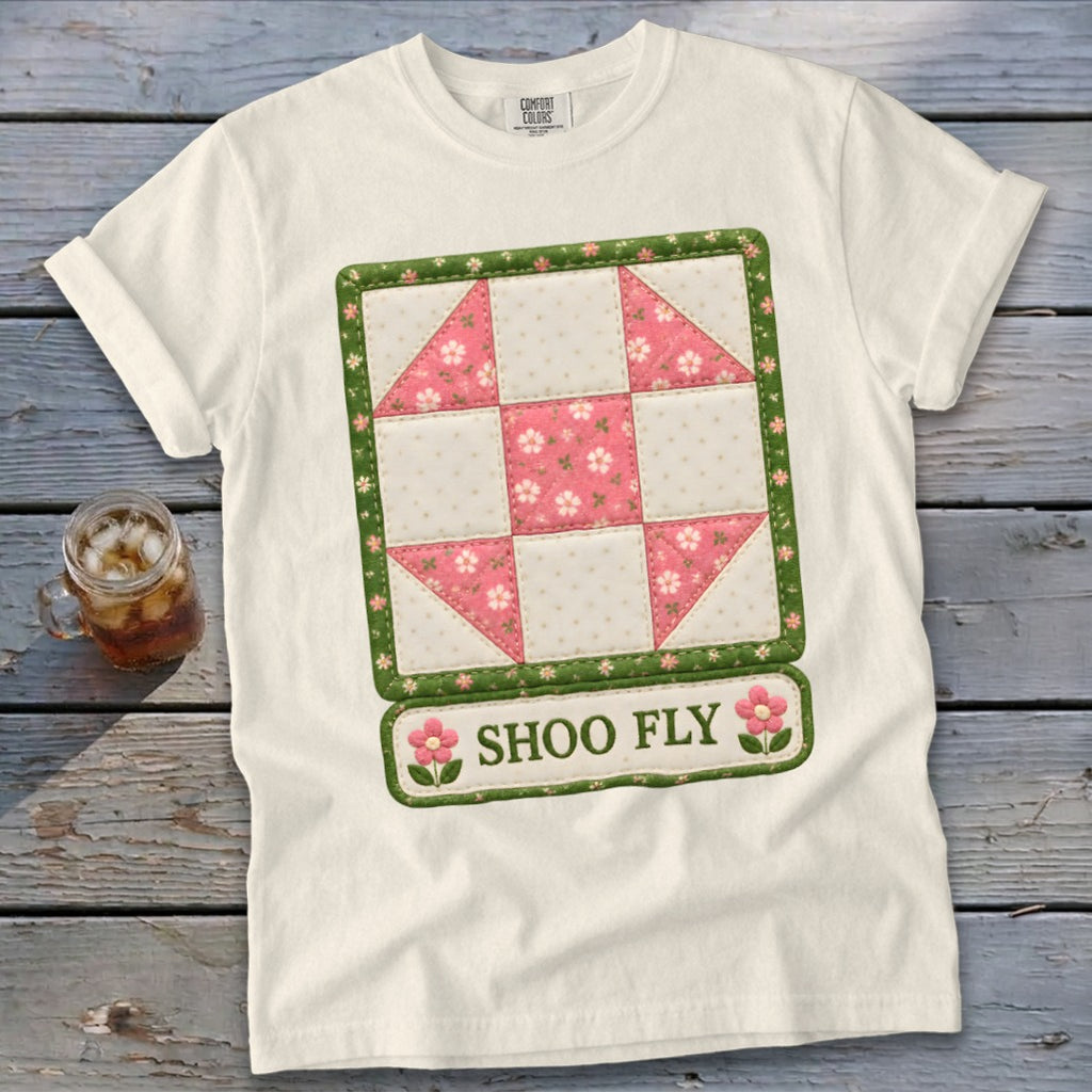 White t-shirt with a "Shoo Fly" quilt block graphic and floral accents.