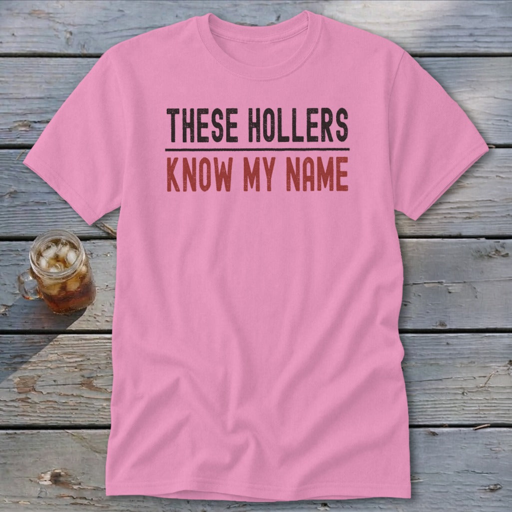 Pink t-shirt with "THESE HOLLERS KNOW MY NAME" text.
