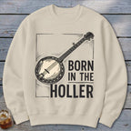 Cream sweatshirt with banjo graphic and text "BORN IN THE HOLLER".