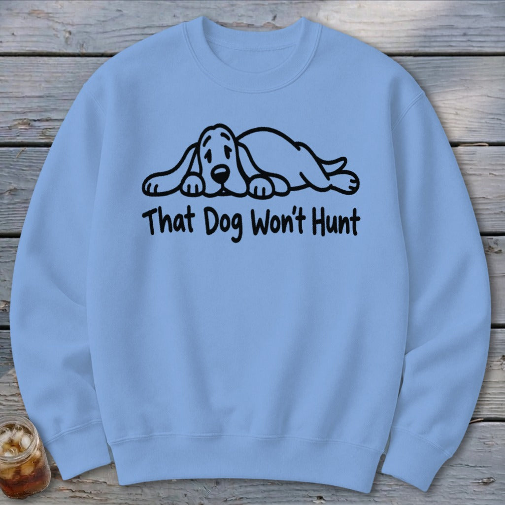 Light blue crewneck sweatshirt featuring a black graphic of a sleeping hound dog and the text That Dog Won't Hunt.